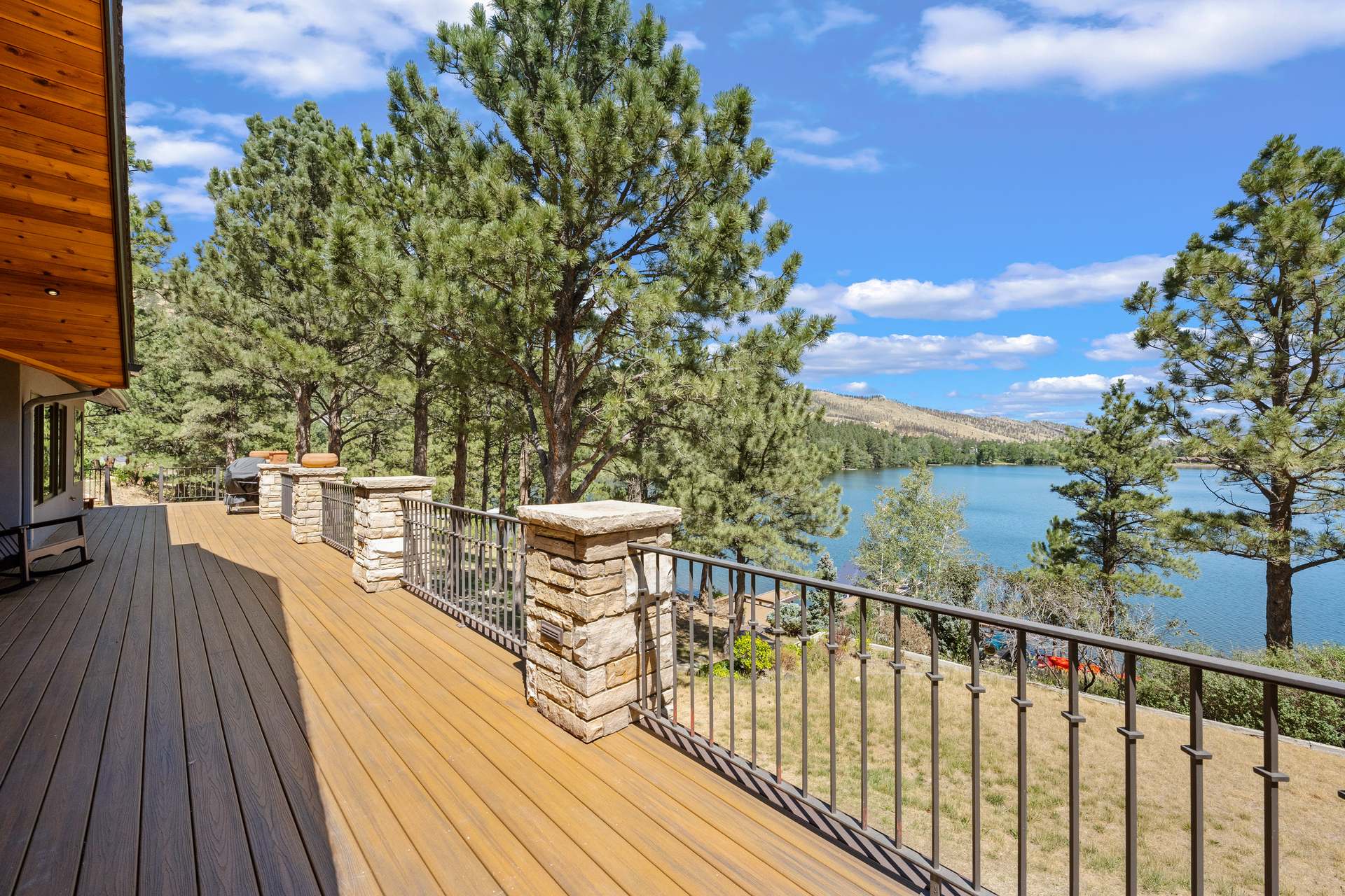 Composite deck with iron railings and stone piers overlooking the lake