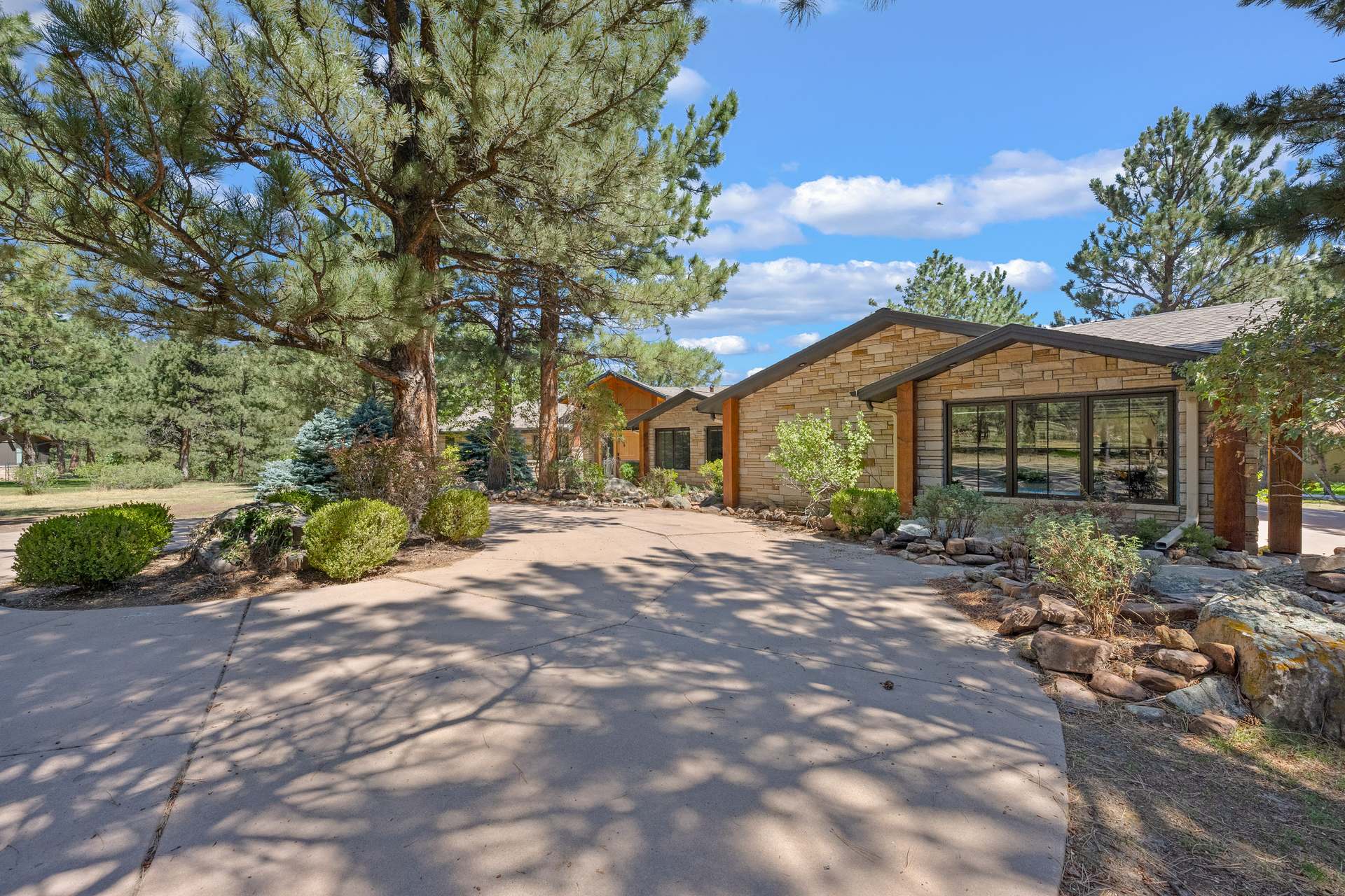 Stone-and-timber lakefront mountain home built by Prana Construction, set among ponderosa pines