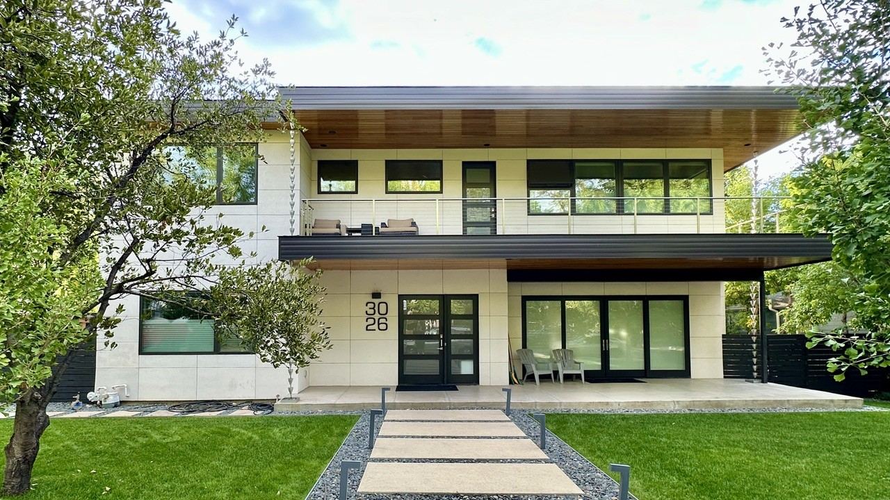 Completed whole-home remodel in Boulder, CO — modern two-story exterior with cedar soffits and covered patio