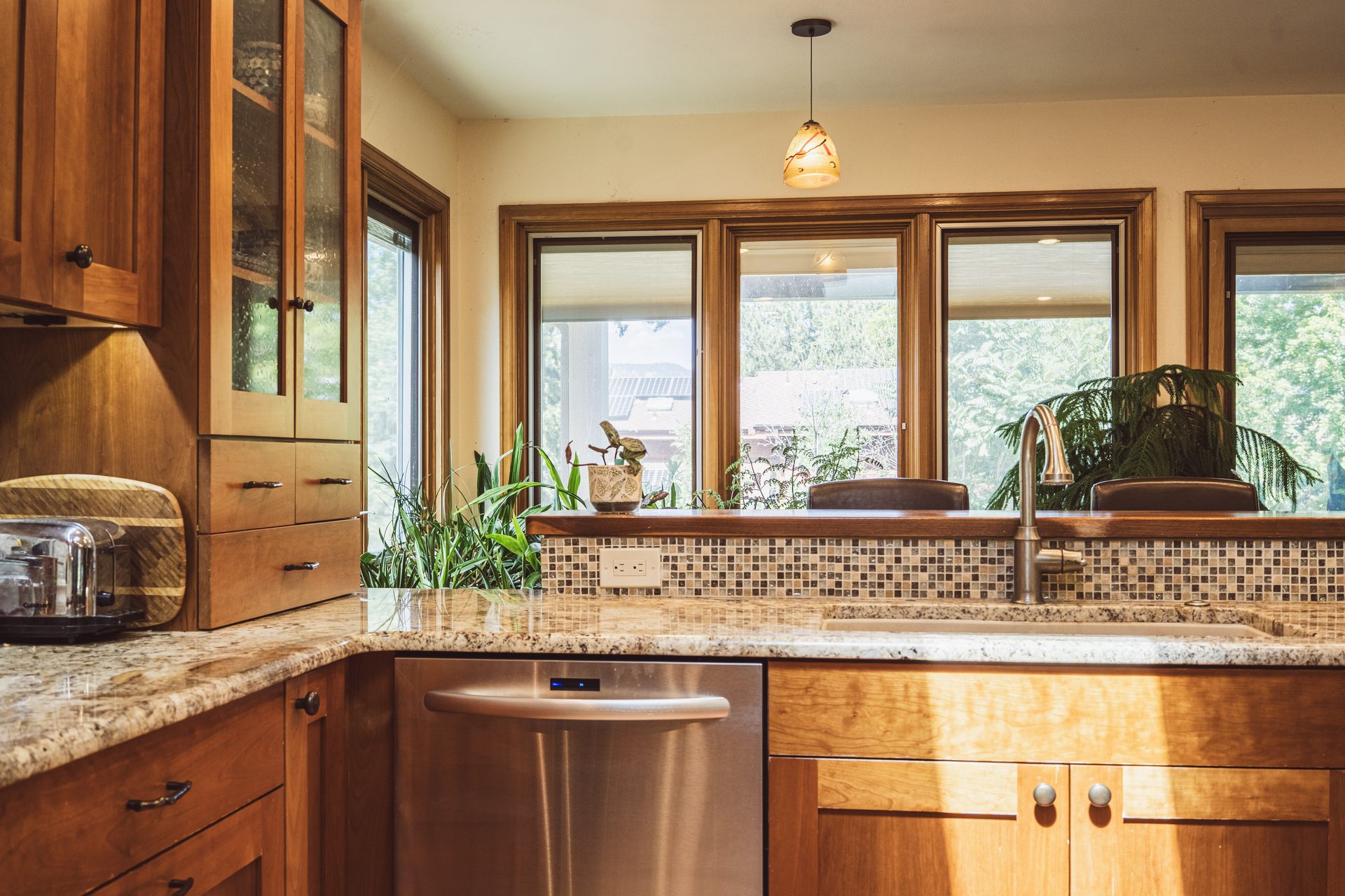 Kitchen remodel with granite countertops, mosaic tile backsplash, and stainless appliances