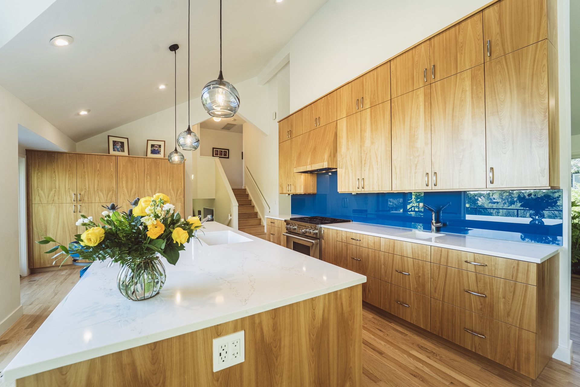 Remodeled kitchen with quartz waterfall island, custom cabinets, and pendant lighting