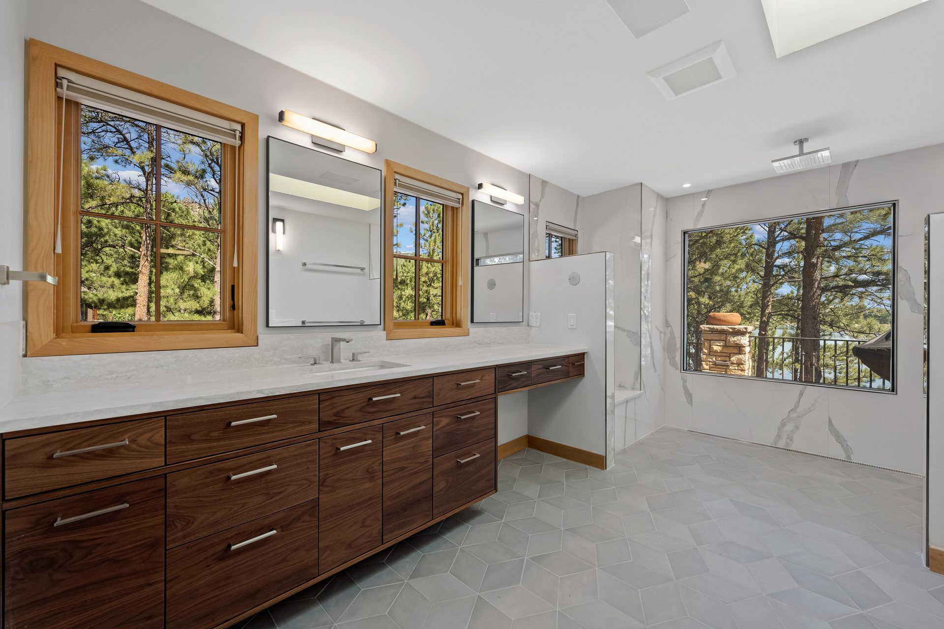 Primary bathroom with floating walnut double vanity and marble-tile walk-in shower